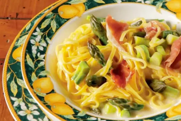 Fotografia del piatto di Mezzanelle Andalini con culatello, asparagi e burro al limone su una tavola apparecchiata