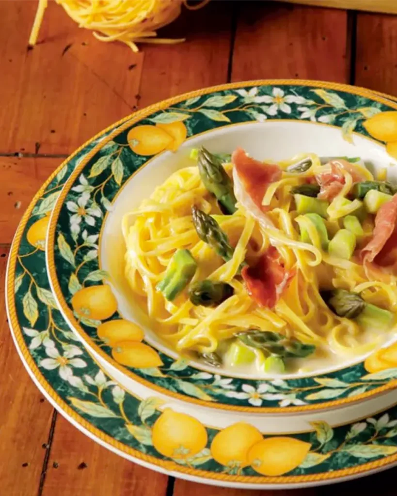 Fotografia del piatto di Mezzanelle Andalini con culatello, asparagi e burro al limone su una tavola apparecchiata